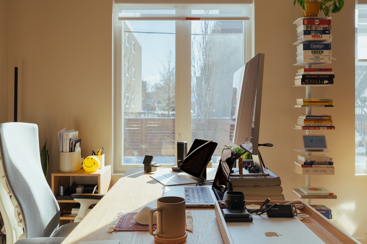 Sunlit desk workspace by a large window inside a backyard office